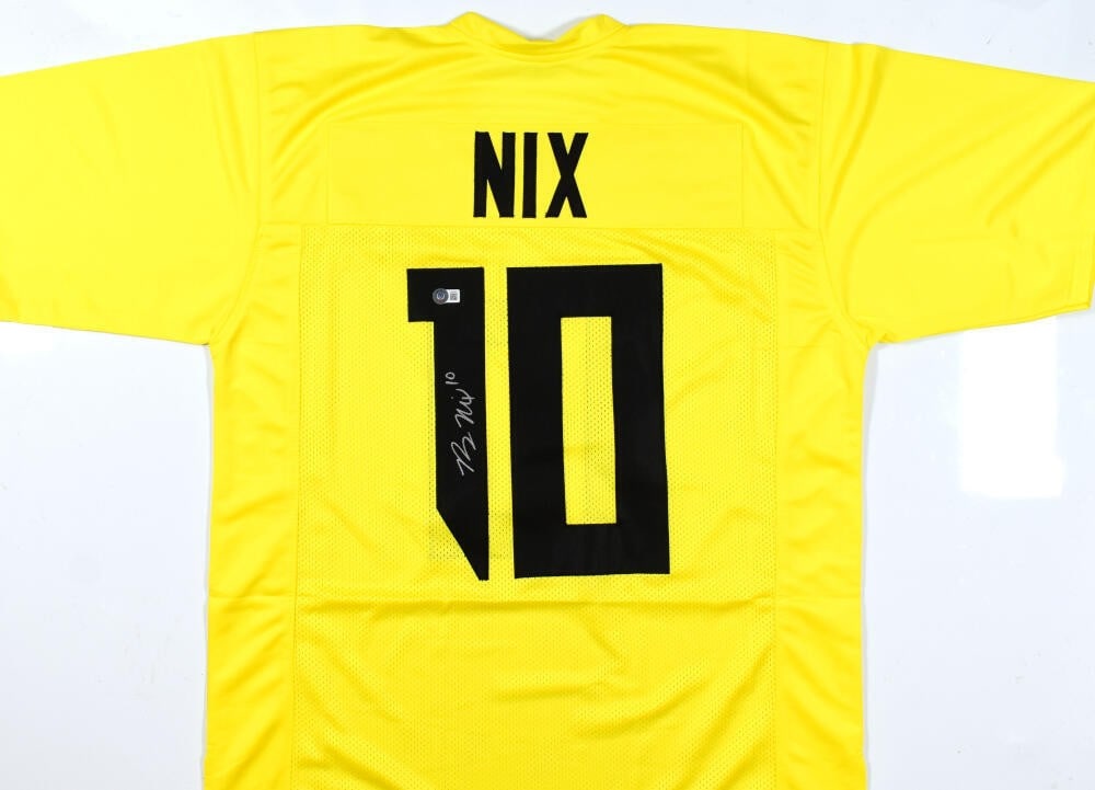 Bo Nix Signed Oregon Ducks Yellow Jersey Beckett Authenticated: Bo Nix Signed Oregon Ducks Yellow Jersey Beckett Authenticated This is an original yellow college-style jersey representing the Oregon Ducks, autographed by Bo Nix. The jersey is authenticated by Beck