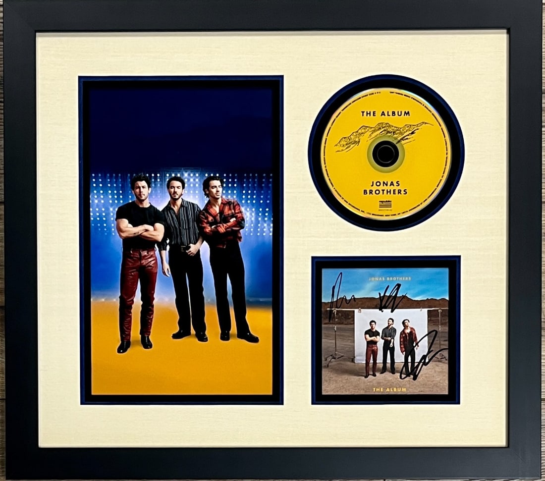 Jonas Brothers Signed CD Insert Custom Framed Display JSA Authenticated: Jonas Brothers Signed CD Insert Custom Framed Display JSA Authenticated This professionally framed display features a signed CD insert from The Jonas Brothers' "The Album." The insert is authentically