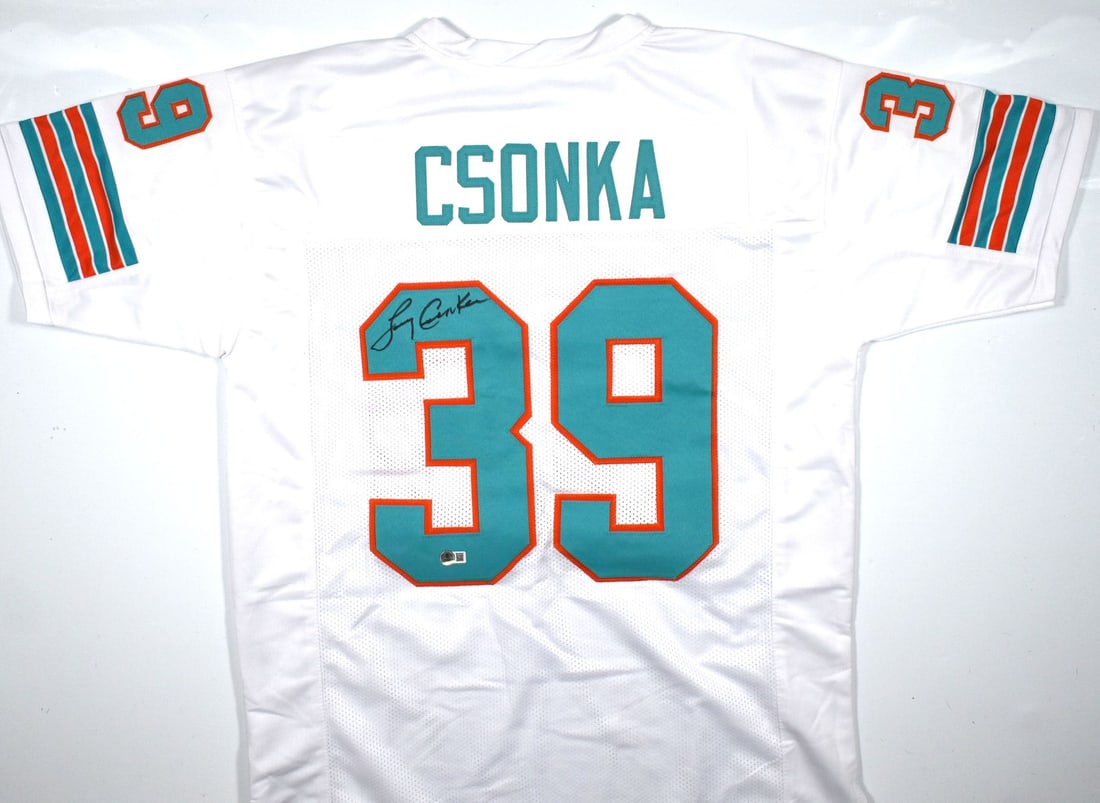 Larry Csonka Signed Miami Dolphins Jersey With Beckett W Authentication: Larry Csonka Signed Miami Dolphins Jersey With Beckett W Authentication This white pro style football jersey is autographed by Larry Csonka and features a Beckett W hologram for authentication. The je
