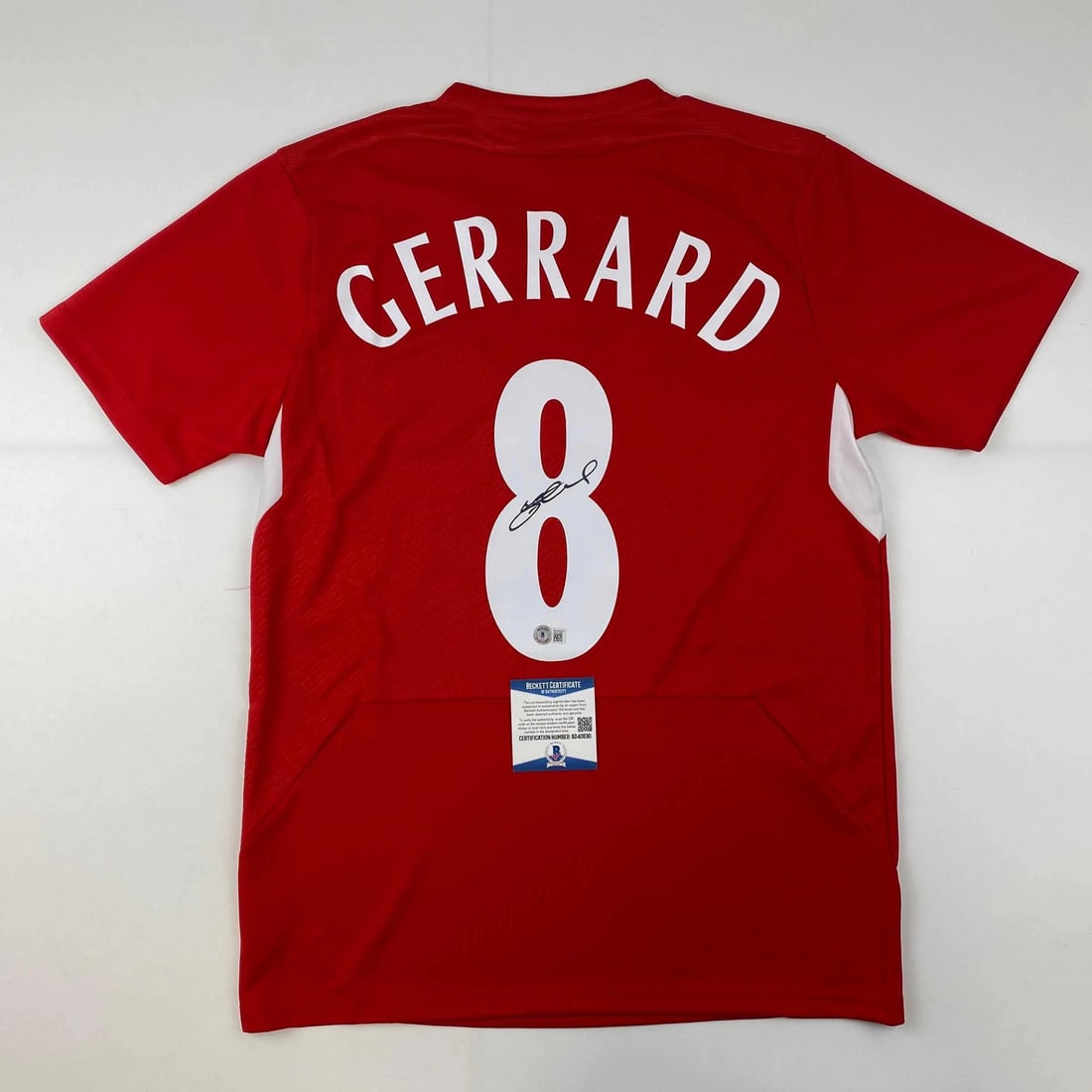 Steven Gerrard Signed Liverpool Red Soccer Jersey Gem Mint Beckett COA: Steven Gerrard Signed Liverpool Red Soccer Jersey Gem Mint Beckett COA Celebrate your passion for soccer with this autographed Steven Gerrard Liverpool red soccer jersey. This original, custom jersey 