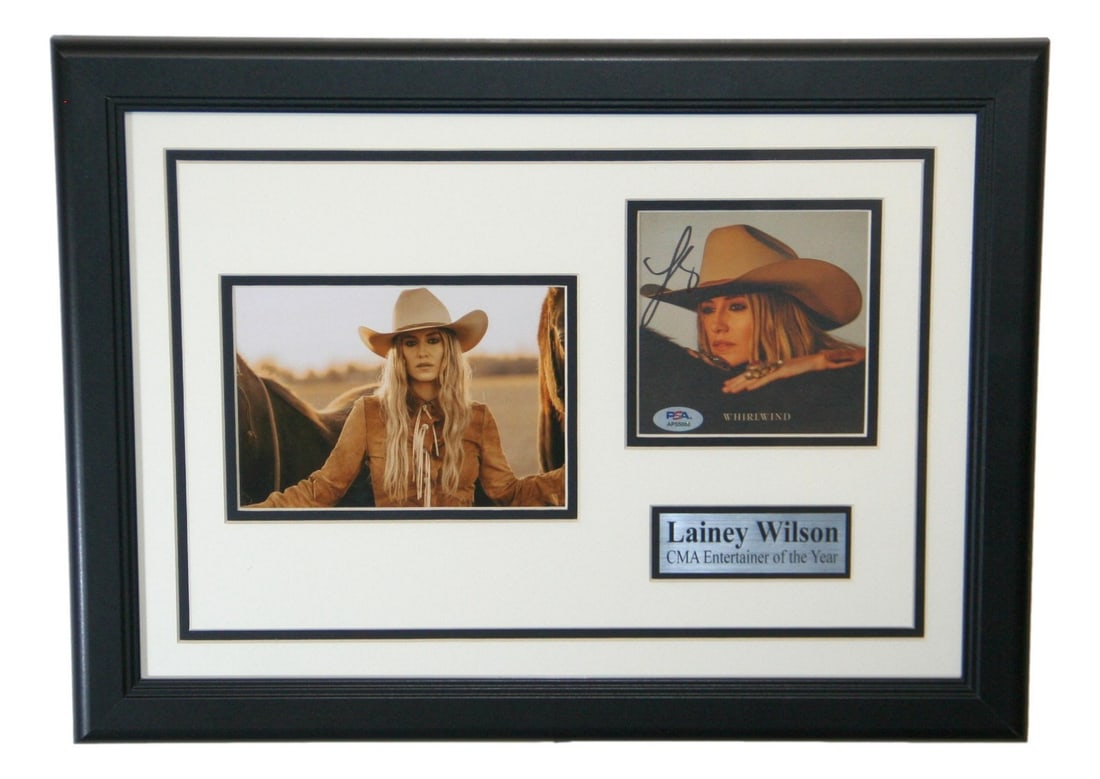 Framed Lainey Wilson Signed CD Cover and Photograph PSA DNA Authenticated: Framed Lainey Wilson Signed CD Cover and Photograph PSA DNA Authenticated This framed display features an original CD cover autographed by Lainey Wilson, accompanied by a photo. The autograph has been