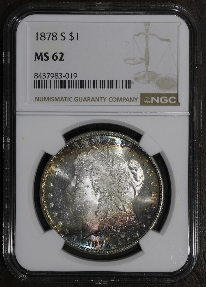 PCGS MS62 1879-S Morgan Silver Dollar Rainbow Toned Holder Error: PCGS MS62 1879-S Morgan Silver Dollar Rainbow Toned Holder Error This is an 1879-S Morgan Silver Dollar graded MS62 by PCGS. The coin features rainbow toning and is noted to have a holder error. It is