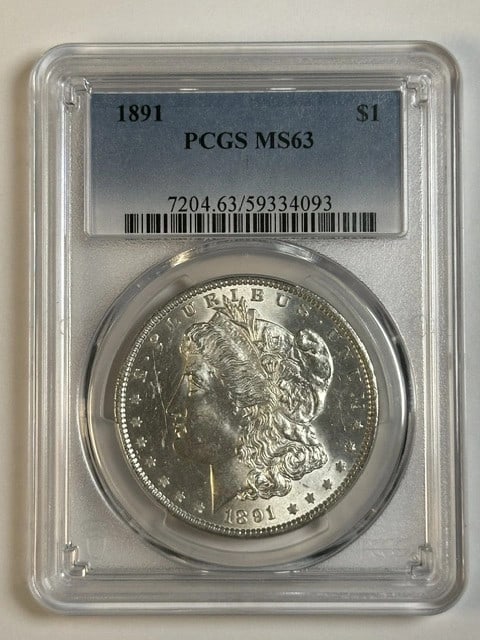 PCGS MS63 1891 Morgan Silver Dollar Philadelphia Mint: PCGS MS63 1891 Morgan Silver Dollar Philadelphia Mint This 1891 Morgan Silver Dollar was minted in Philadelphia and is graded MS 63 by PCGS. Composed of silver, this uncirculated coin is a desirable p