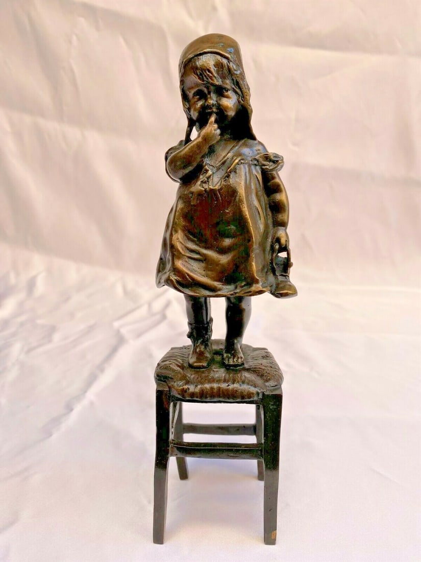 1900 Bronze Girl Statue by Juan Clara Signed Art: 1900 Bronze Girl Statue by Juan Clara Signed Art This exquisite bronze statue, created by renowned Spanish artist Juan Clara in the early 1900s, depicts a young girl standing on a chair, delicately ho