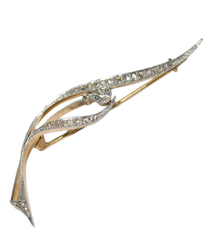 Art Deco 18k Two Tone Gold Diamond Brooch: Art Deco 18k Two Tone Gold Diamond Brooch This Art Deco brooch is crafted from 18k white and yellow gold and weighs 5.7 grams. Featuring a central old European cut diamond of approximately 0.30 carats