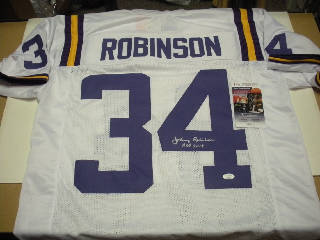 Signed Johnny Robinson LSU Football Jersey with JSA COA: Signed Johnny Robinson LSU Football Jersey with JSA COA This pre-owned white jersey is signed by Johnny Robinson, commemorating his career with the LSU Tigers and his induction into the Hall of Fame i