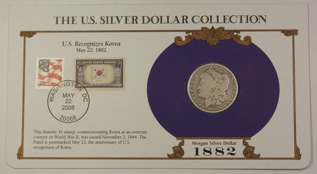 1882-O Morgan Dollar in Postmarked Holder with Two Commemorative Stamps: 1882-O Morgan Dollar in Postmarked Holder with Two Commemorative Stamps This 1882-O Morgan Silver Dollar is a $1 coin minted in New Orleans and comes in a postmarked Informational Postal Commemorative