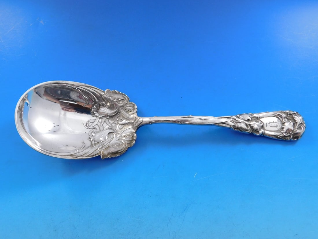 Durgin New Art Sterling Silver Berry Spoon 9 3/8" Iris Motif: Durgin New Art Sterling Silver Berry Spoon 9 3/8" Iris Motif This exquisite serving spoon features the New Art pattern by Durgin, showcasing a stunning Iris motif. Crafted from sterling silver, this 9