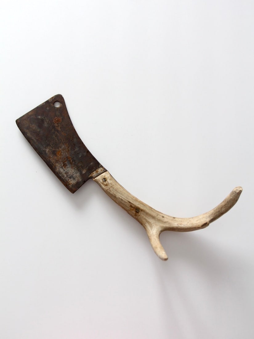 Vintage Cleaver with Three-Point Antler Handle 17 in: Vintage Cleaver with Three-Point Antler Handle 17 in This vintage cleaver features a beautifully crafted handle made from a three-point antler, showcasing its unique and rustic charm. The cleaver is i