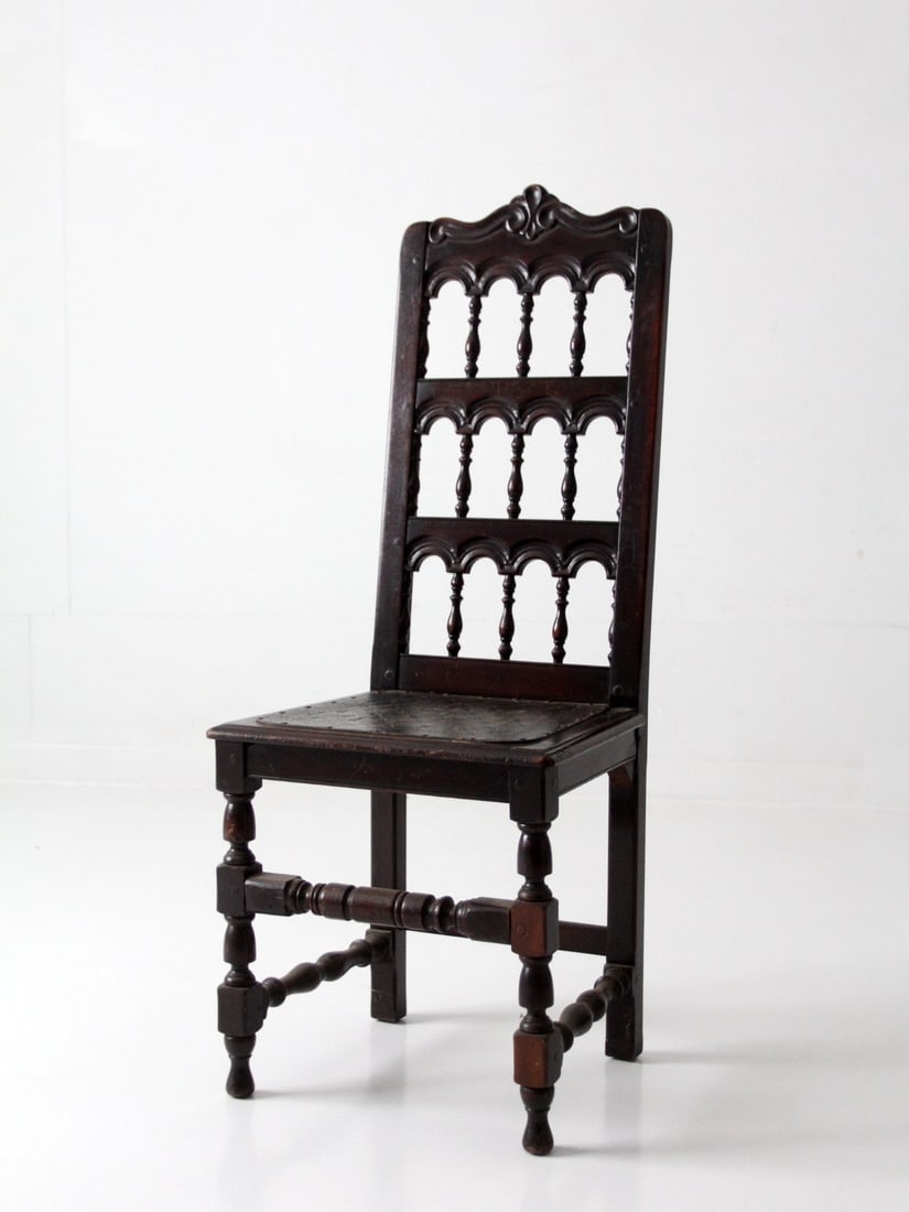 Victorian Era Spindle Back Wood Chair Featuring Leather Upholstered Seat: Victorian Era Spindle Back Wood Chair Featuring Leather Upholstered Seat This antique Victorian spindle back chair features a carved crest, repeating rows of turned spindles, and soft arches. The tall