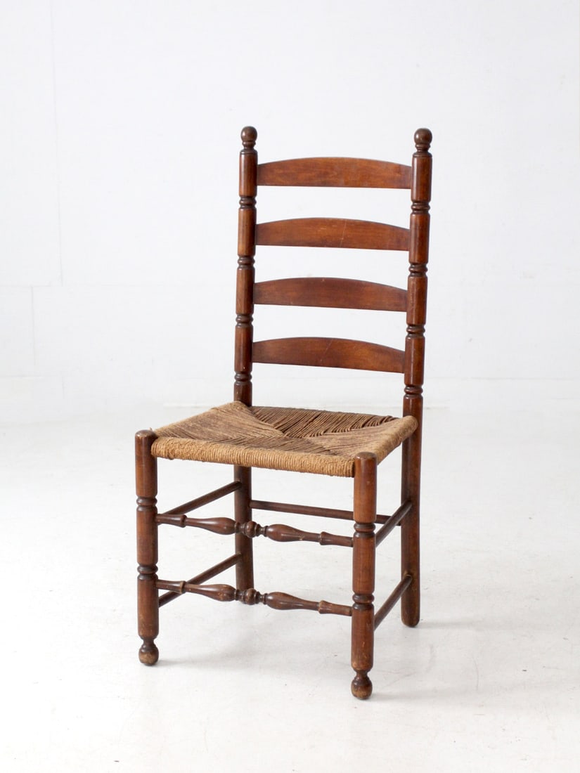 Antique Ladder Back Chair with Handwoven Rush Seat: Antique Ladder Back Chair with Handwoven Rush Seat This antique ladder back chair showcases traditional craftsmanship with its handwoven rush seat and turned wood frame, exuding rustic charm. The tall
