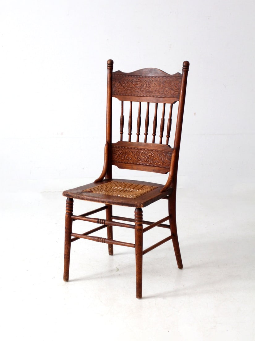 Antique Late 1800s Pressed Back Dining Chair with Cane Seat: Antique Late 1800s Pressed Back Dining Chair with Cane Seat This exquisite antique pressed back dining chair, dating from the late 1800s, showcases a beautifully detailed floral pressed back rail alon