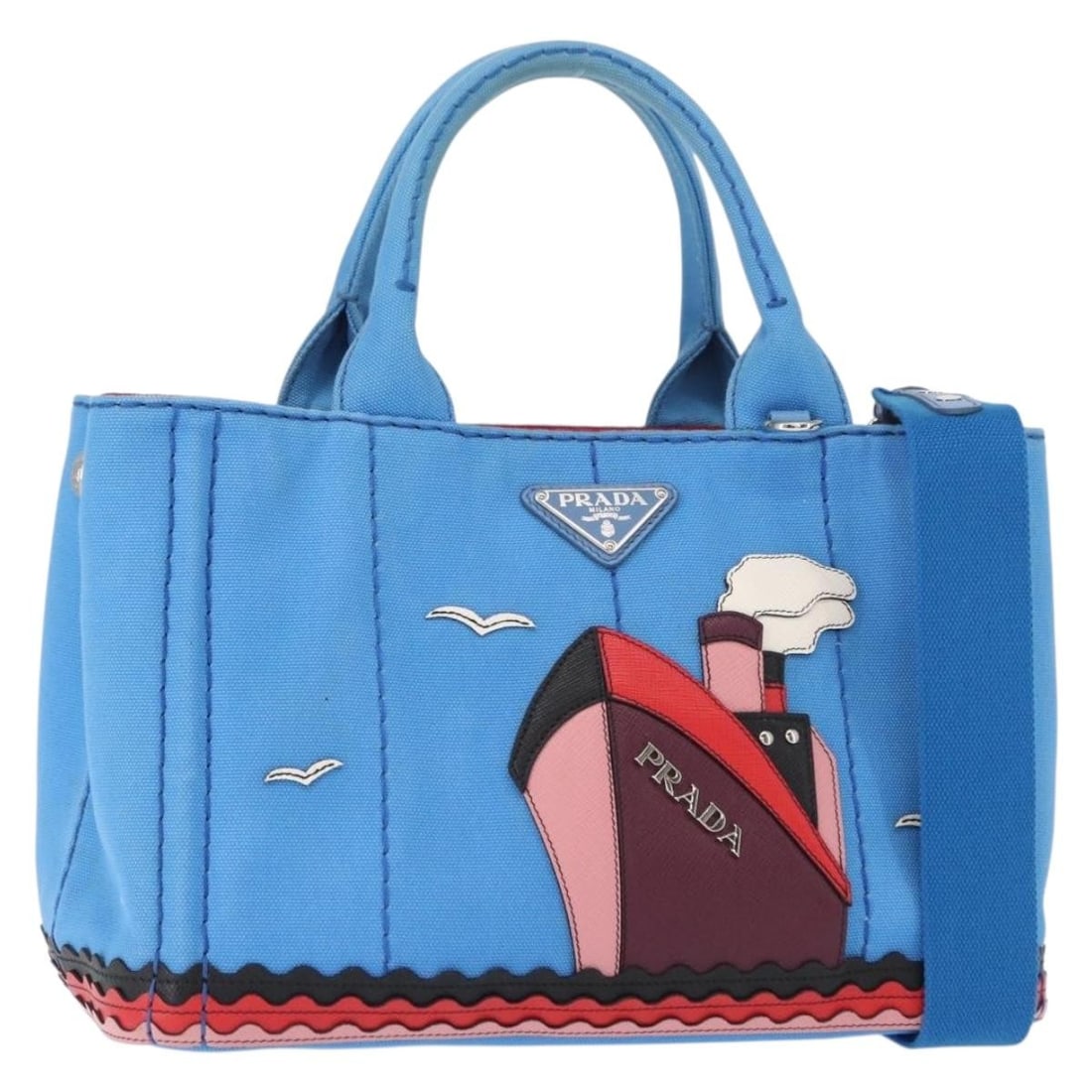 Blue Canvas Canapa Convertible Tote by Prada with Applique Detailing: Blue Canvas Canapa Convertible Tote by Prada with Applique Detailing This Prada Canapa Convertible Tote is crafted from blue canvas and features applique detailing. Designed for women, it has a practi