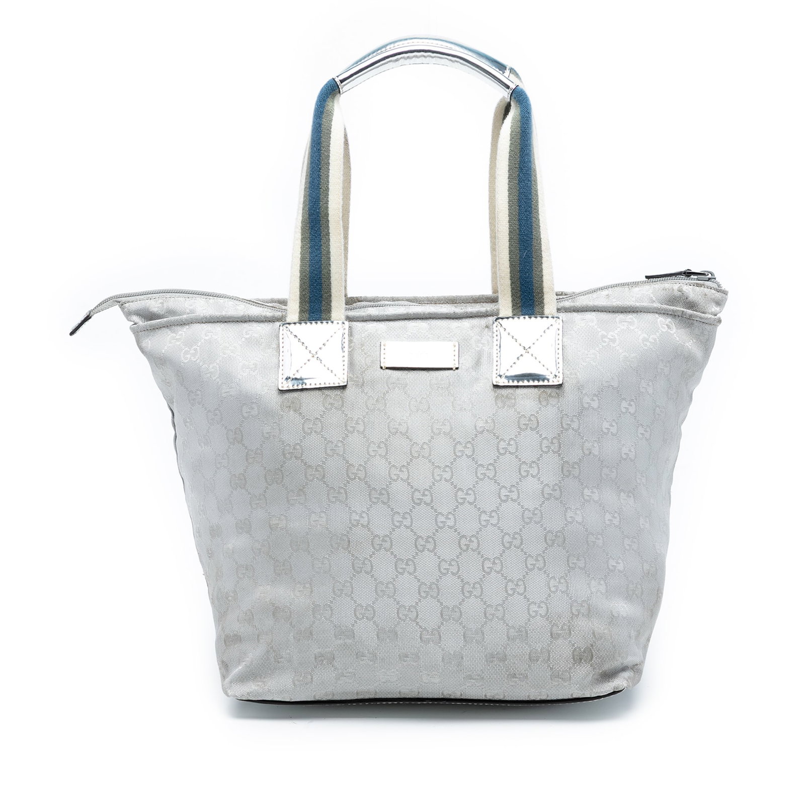 GG Canvas Web Shoulder Tote Bag by Gucci in Silver Fabric: GG Canvas Web Shoulder Tote Bag by Gucci in Silver Fabric This Gucci GG Canvas Web Tote features a canvas body, flat web shoulder straps, a top zip closure, and an interior zip pocket. The tote is cra