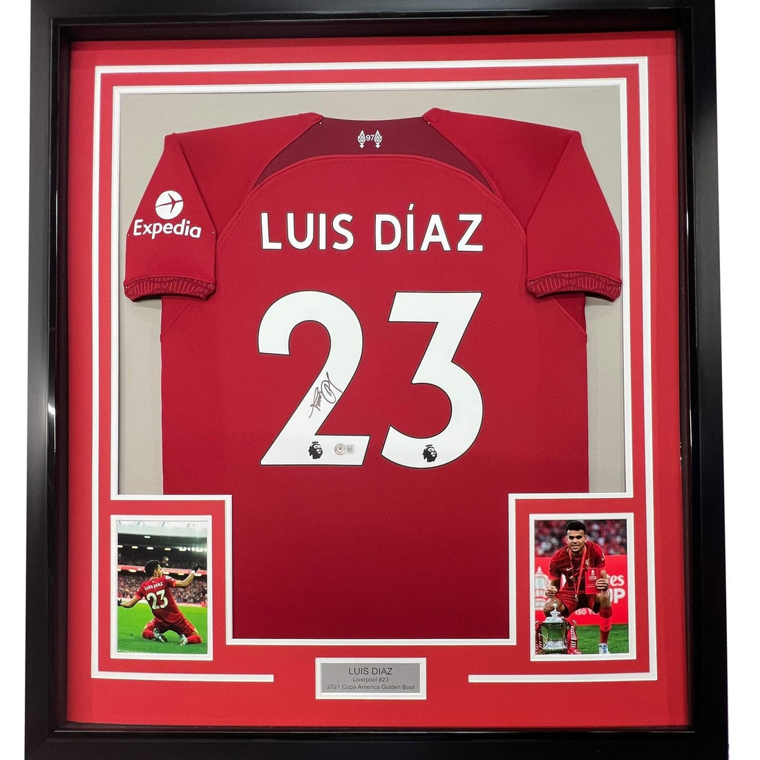 Framed Liverpool Jersey Signed by Luis Diaz 33x42 BAS COA: Framed Liverpool Jersey Signed by Luis Diaz 33x42 BAS COA This is a professionally framed and matted Liverpool red soccer jersey autographed by Luis Diaz. The display includes two 8x10 photos and meas