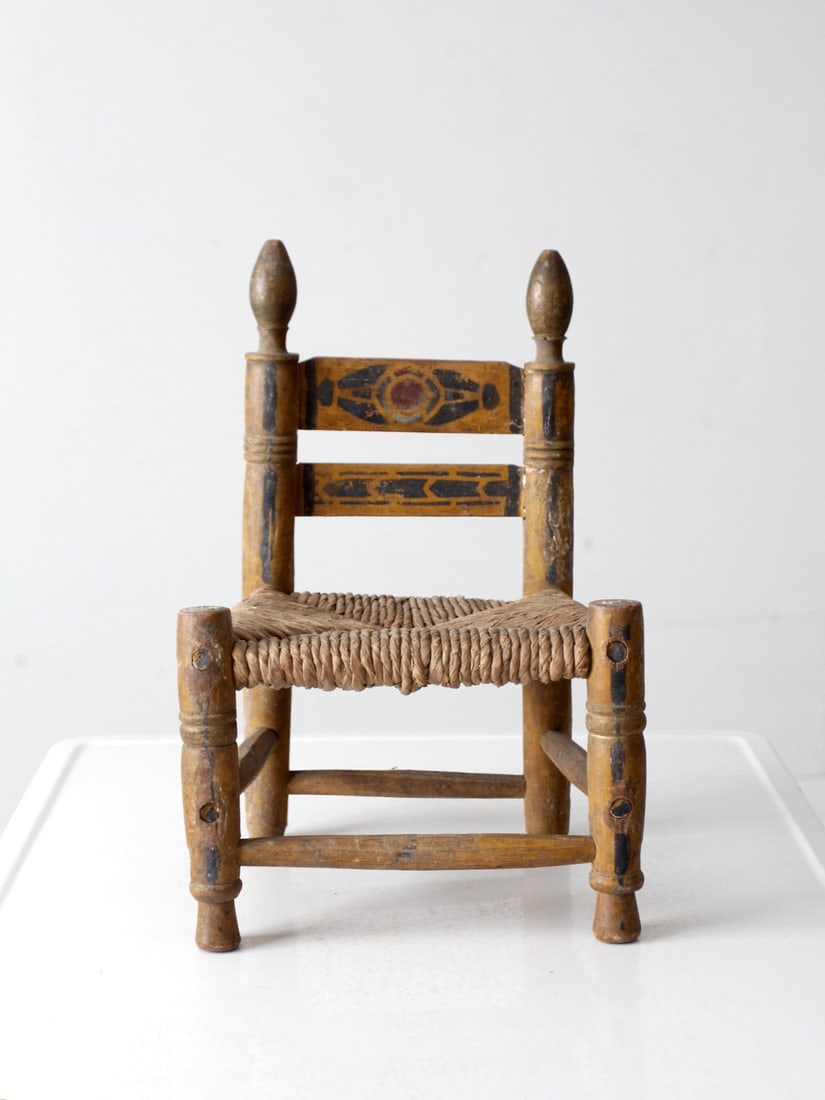 Charming Vintage Mexican Folk Art Children's Chair: Charming Vintage Mexican Folk Art Children's Chair This charming vintage Mexican children's chair is a beautiful example of folk art, featuring turned wood posts adorned with finials and hand-painted 