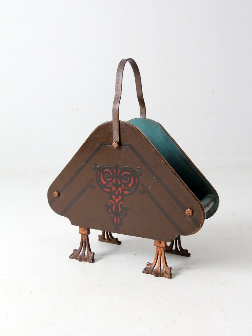 Charming Antique Folk Art Magazine Rack with Copper Accents: Charming Antique Folk Art Magazine Rack with Copper Accents This antique magazine rack features a charming folk art design, characterized by its triangular shape, wooden body, and decorative copper ac