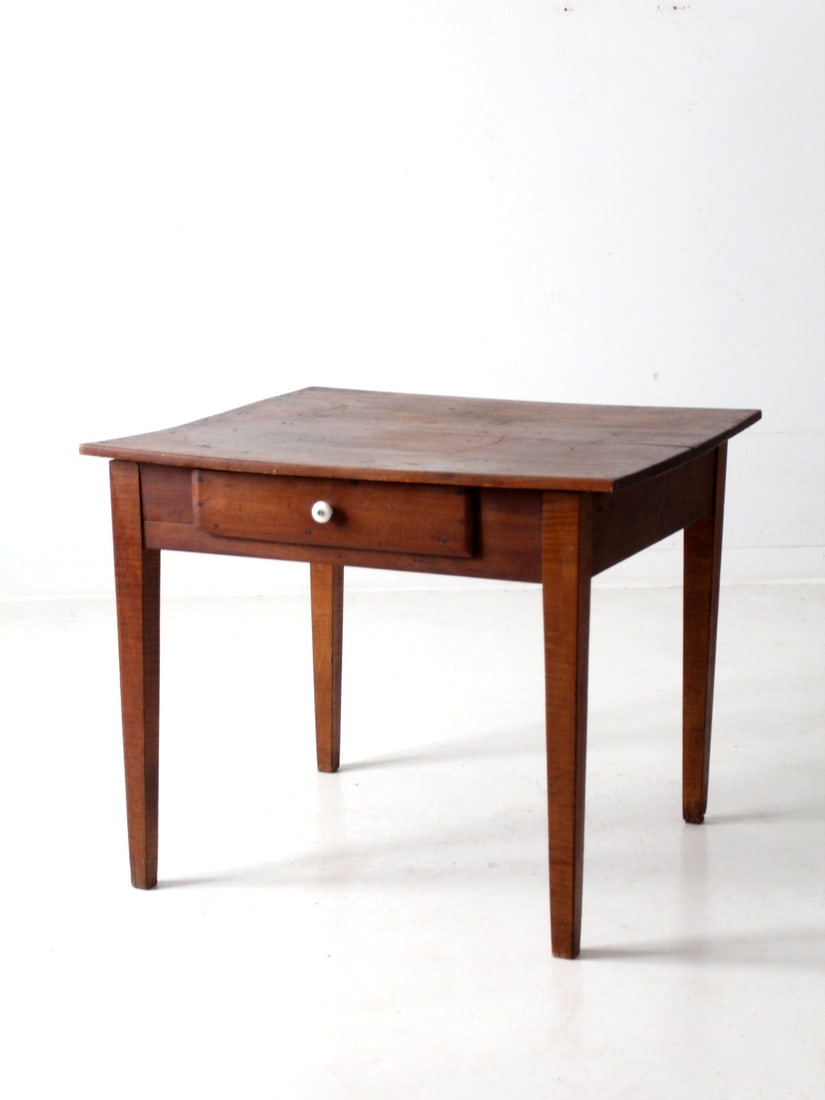 Charming Antique Primitive Table with Drawer and Tapered Legs: Charming Antique Primitive Table with Drawer and Tapered Legs This antique primitive table showcases a simple yet elegant design, featuring tapered legs and a double plank tabletop. It includes a sing