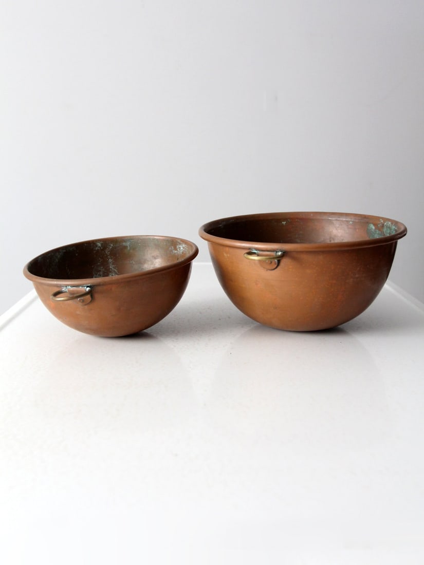 Pair of Antique Copper Mixing Bowls with Brass Handles: Pair of Antique Copper Mixing Bowls with Brass Handles This pair of antique copper mixing bowls features classic round bottoms designed for thorough mixing. Each bowl is equipped with brass ring handl