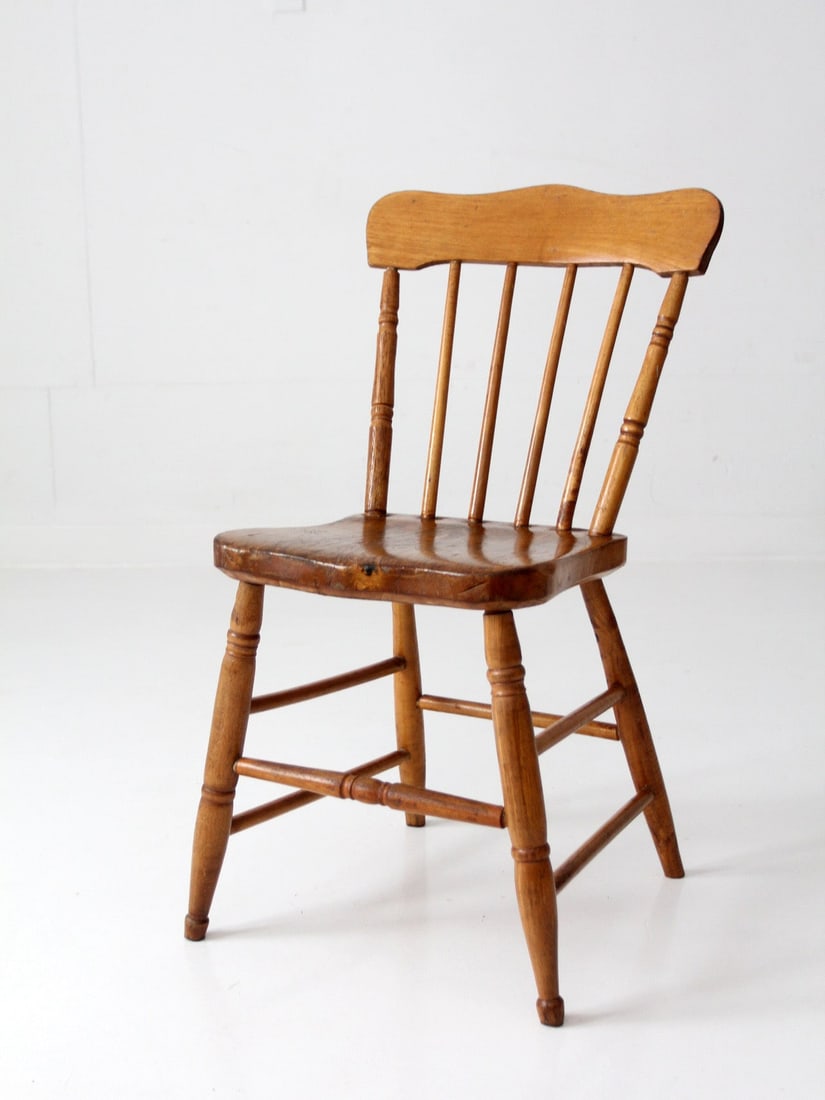Early 20th Century Spindle Back Wooden Farmhouse Chair With Plank Seat: Early 20th Century Spindle Back Wooden Farmhouse Chair With Plank Seat This early 20th-century farmhouse chair features a solid plank seat, turned legs, and a spindle back. The shaped crest rail intro