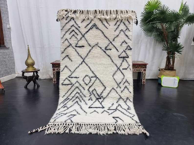Authentic Handmade Moroccan Berber Wool Rug 3.28 x 6.56 Feet: Authentic Handmade Moroccan Berber Wool Rug 3.28 x 6.56 Feet Experience the elegance of this authentic Soft White Handmade Moroccan Berber Wool Rug, featuring a striking black assorted pattern. Handwo