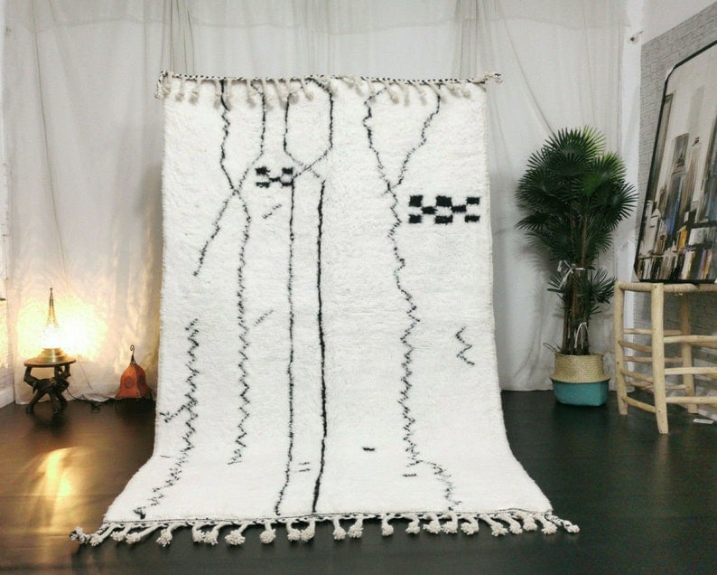 Handmade Moroccan Berber Wool Rug 8x5 Feet White with Black Patterns: Handmade Moroccan Berber Wool Rug 8x5 Feet White with Black Patterns Enhance your living space with this stunning Soft White Handmade Moroccan Berber Wool Rug. This exquisite rug features intricate bl