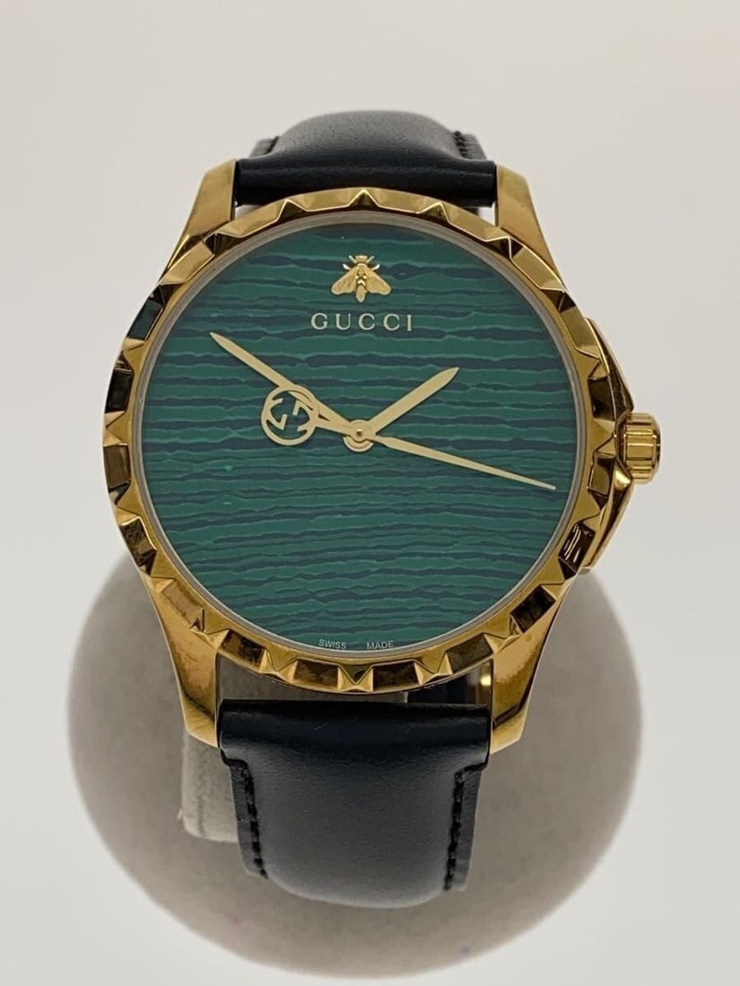 Gucci G Timeless men's quartz wristwatch YA126463A green leather: Gucci G Timeless men's quartz wristwatch YA126463A green leather This is a pre-owned GUCCI G-TIMELESS men's wristwatch featuring a quartz movement. The watch has a green dial and is crafted with a lea