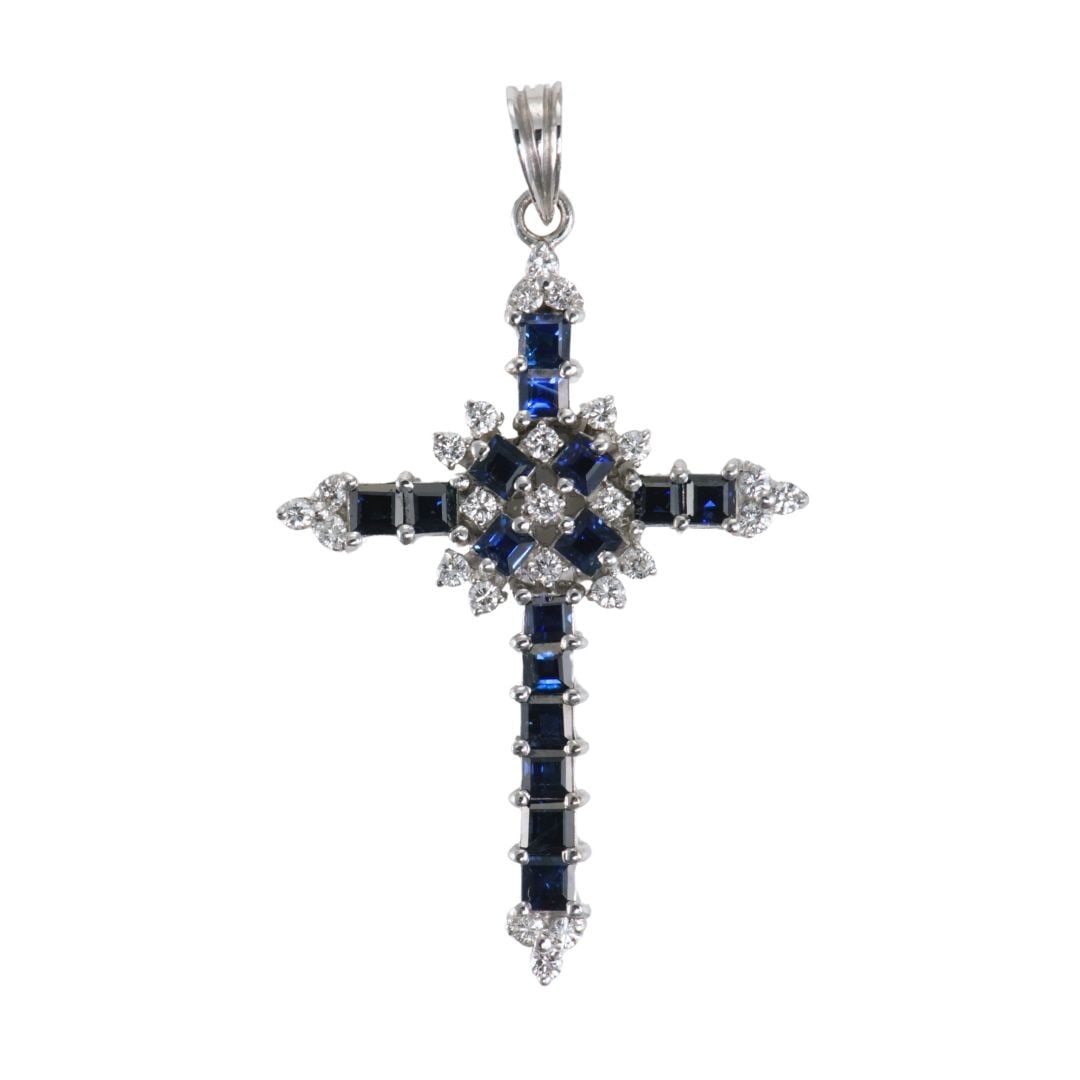 White Gold Cross Pendant with Sapphire and 25 Diamonds: White Gold Cross Pendant with Sapphire and 25 Diamonds This elegant cross pendant features deep blue natural sapphires and sparkling diamonds set in 13K white gold. The pendant is designed in a classi