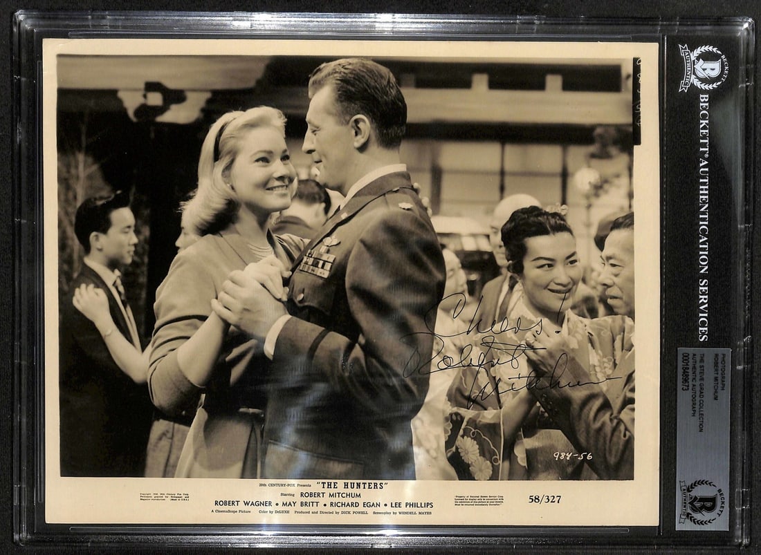 Robert Mitchum Signed 8x10 The Hunters Movie Still BECKETT BAS: Robert Mitchum Signed 8x10 The Hunters Movie Still BECKETT BAS This vintage 8x10 black-and-white movie still photograph features the legendary actor Robert Mitchum, who signed it in black ink. The pho