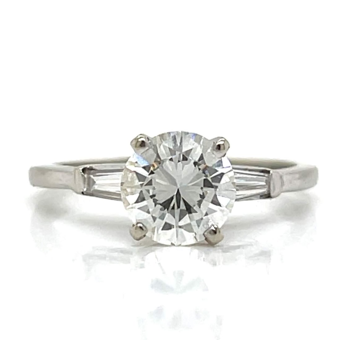 14K White Gold Engagement Ring with 1.20 Ct Diamond and Baguette Accents: 14K White Gold Engagement Ring with 1.20 Ct Diamond and Baguette Accents This exquisite 14K white gold engagement ring features a stunning 1.20 Ct. diamond with H-I color and VVS clarity. Complementin