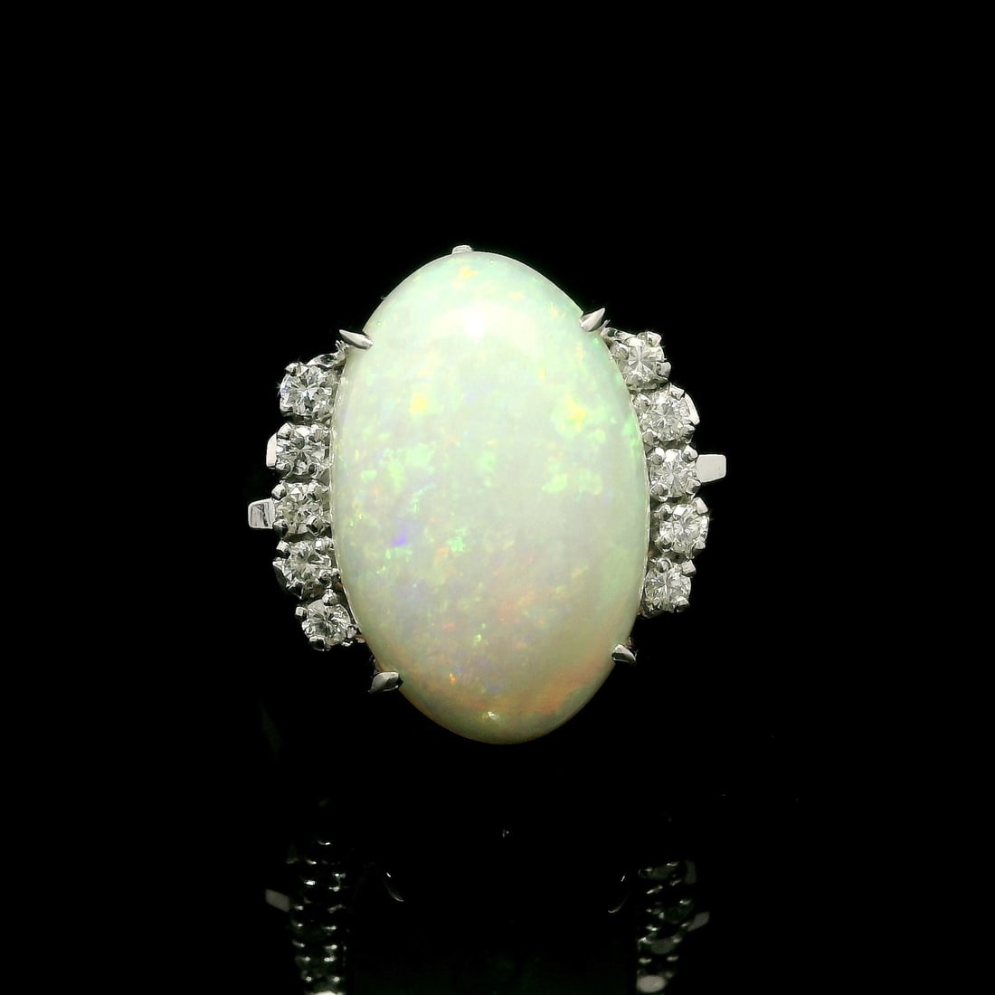 Platinum 6.98ct Oval Opal Diamond Cocktail Ring: Platinum 6.98ct Oval Opal Diamond Cocktail Ring This stunning cocktail ring features a large, natural oval cabochon opal with a captivating play of colors, set in solid platinum. The opal measures 17.