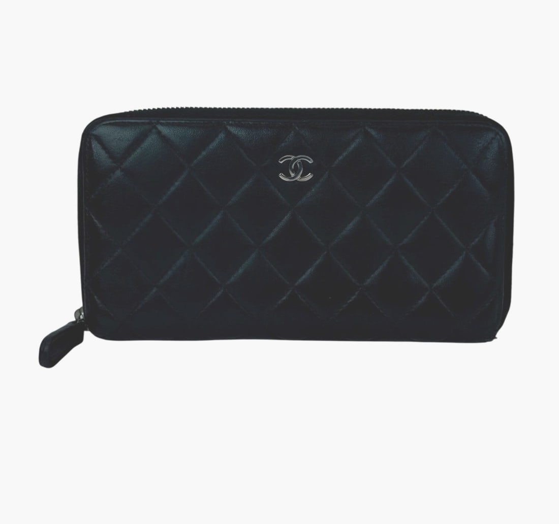 CHANEL Black Zip Around Quilted Lambskin Wallet: CHANEL Black Zip Around Quilted Lambskin Wallet This Chanel Classic wallet features a quilted smooth lambskin leather exterior in black, accented with the iconic diamond pattern. Designed in a medium 