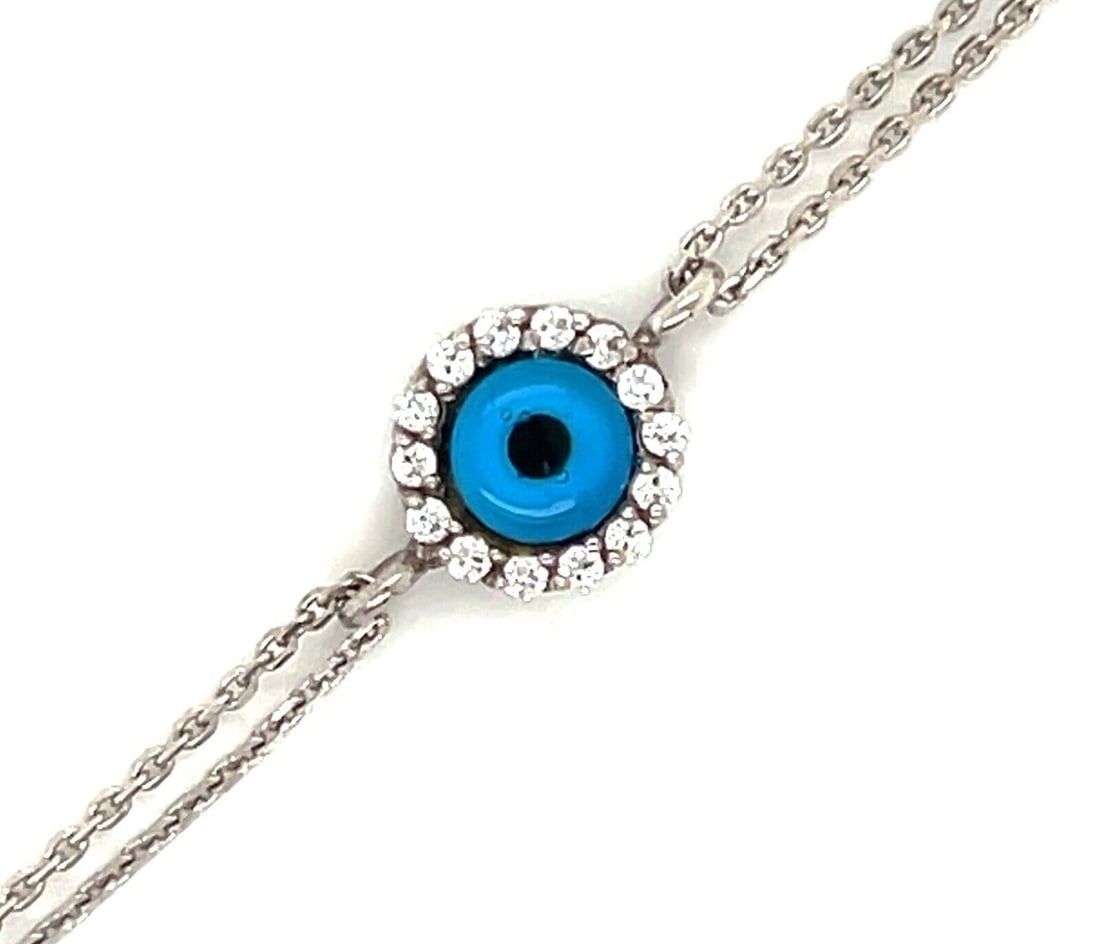 Vintage 14k White Gold Evil Eye Diamond Link Bracelet: Vintage 14k White Gold Evil Eye Diamond Link Bracelet This vintage double-chain bracelet is crafted from solid 14k white gold and features a central round evil eye charm. The centerpiece is accented b