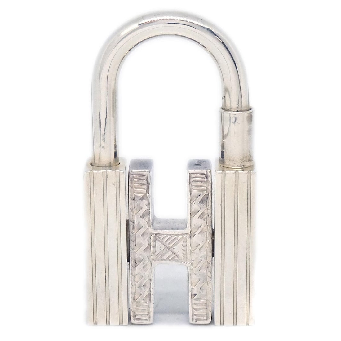 Hermes Touareg H Cadena Small Sterling Silver Padlock: Hermes Touareg H Cadena Small Sterling Silver Padlock This Hermes Touareg H Cadena is crafted from sterling silver and features a distinctive 'H' design on the front with textured sides. The item is i