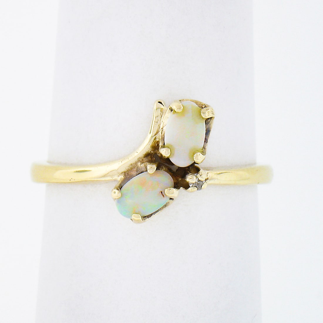 14K Yellow Gold Bypass Ring with 2 Opals and Diamond Accent Size 6.5: 14K Yellow Gold Bypass Ring with 2 Opals and Diamond Accent Size 6.5 This petite bypass ring is crafted from solid 14k yellow gold and features two natural oval cabochon cut opals, each displaying a t