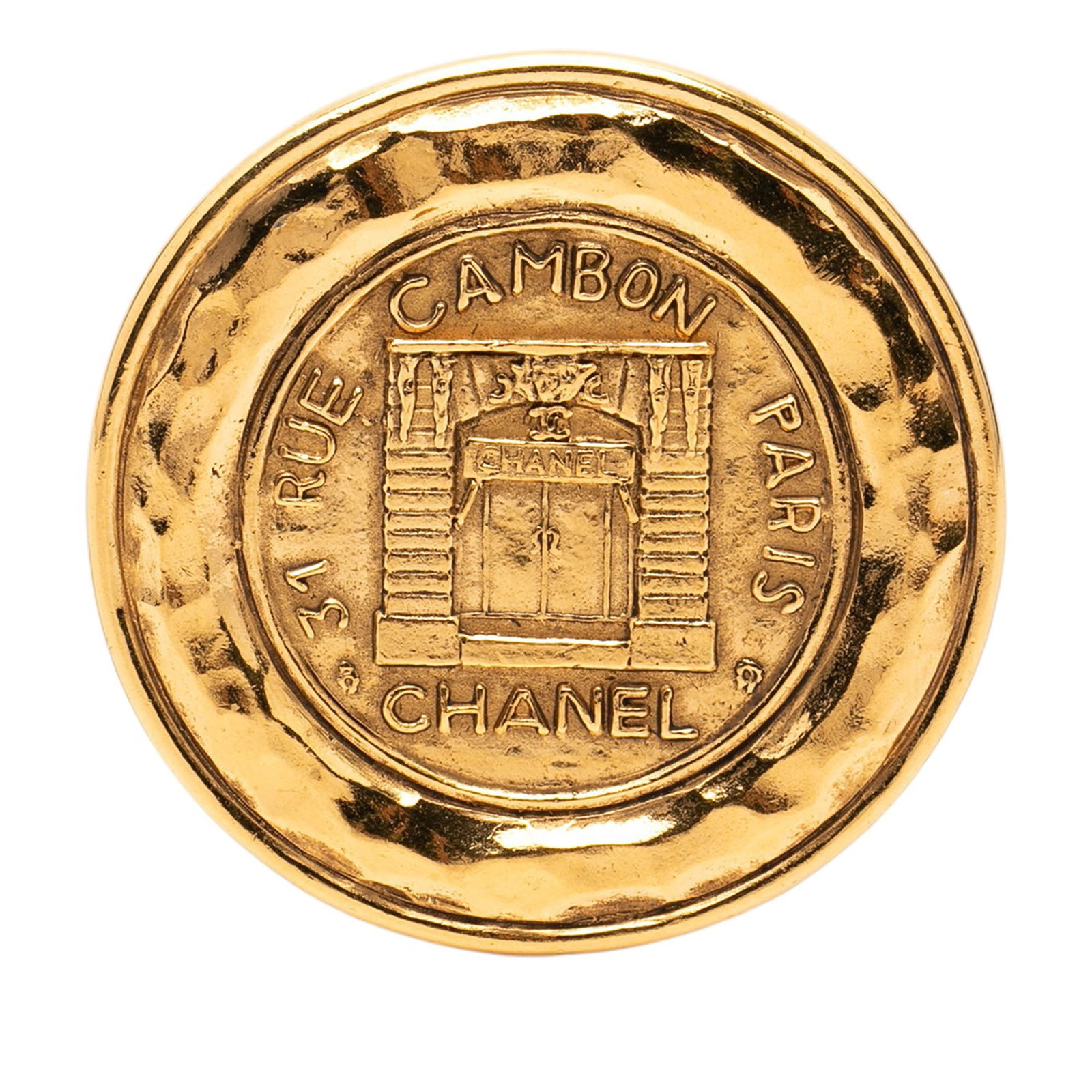 Chanel 31 Rue Cambon Gold Tone Round Brooch: Chanel 31 Rue Cambon Gold Tone Round Brooch This Chanel brooch features a round design crafted from gold-tone metal with a back pin closure. The brooch is a costume jewelry piece and showcases the ico