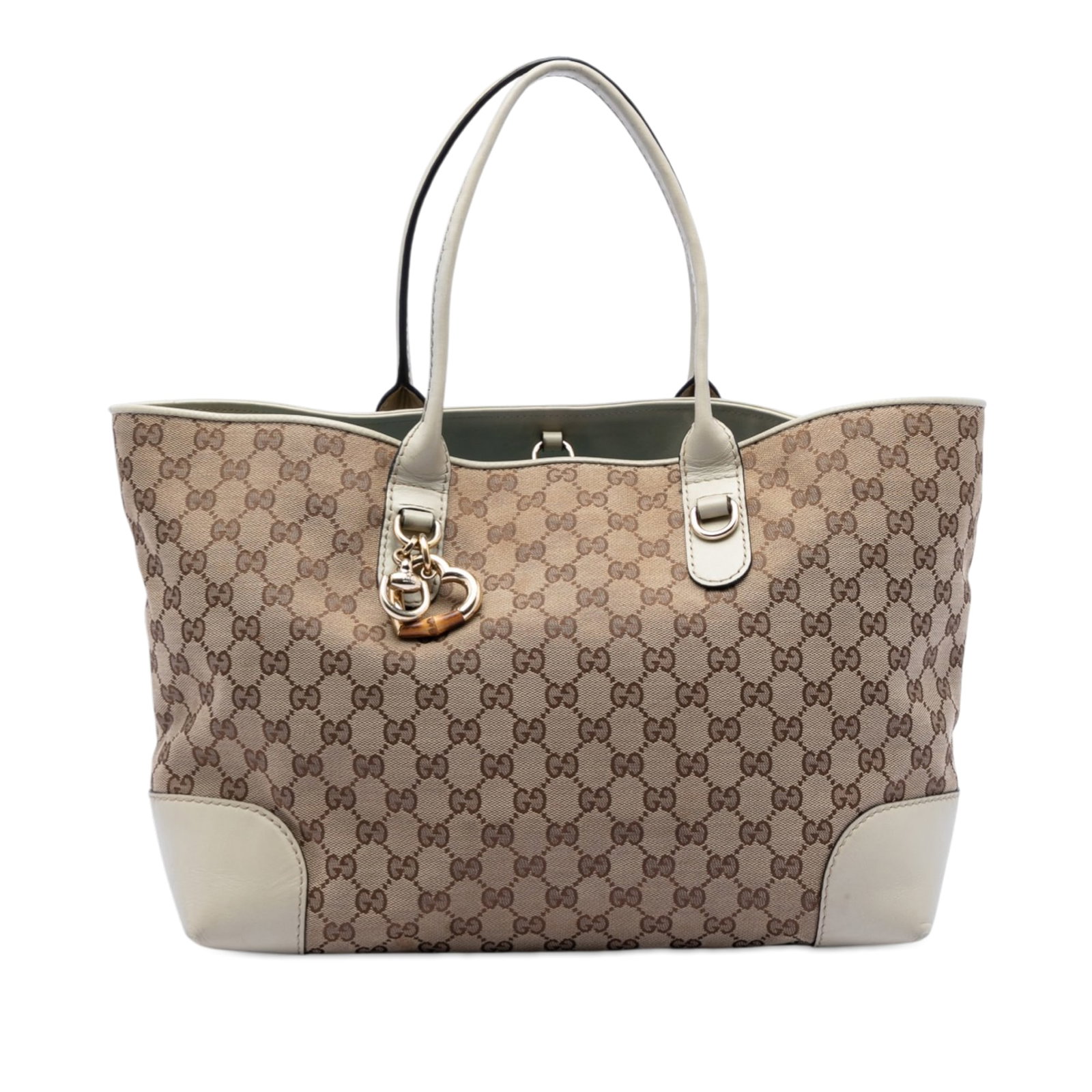 Gucci Heart Bit GG Canvas Beige Tote Bag: Gucci Heart Bit GG Canvas Beige Tote Bag This Gucci GG Canvas Heart Bit Tote features a beige canvas body with leather trim, complemented by flat leather straps and a metal charm. The bag has an open 