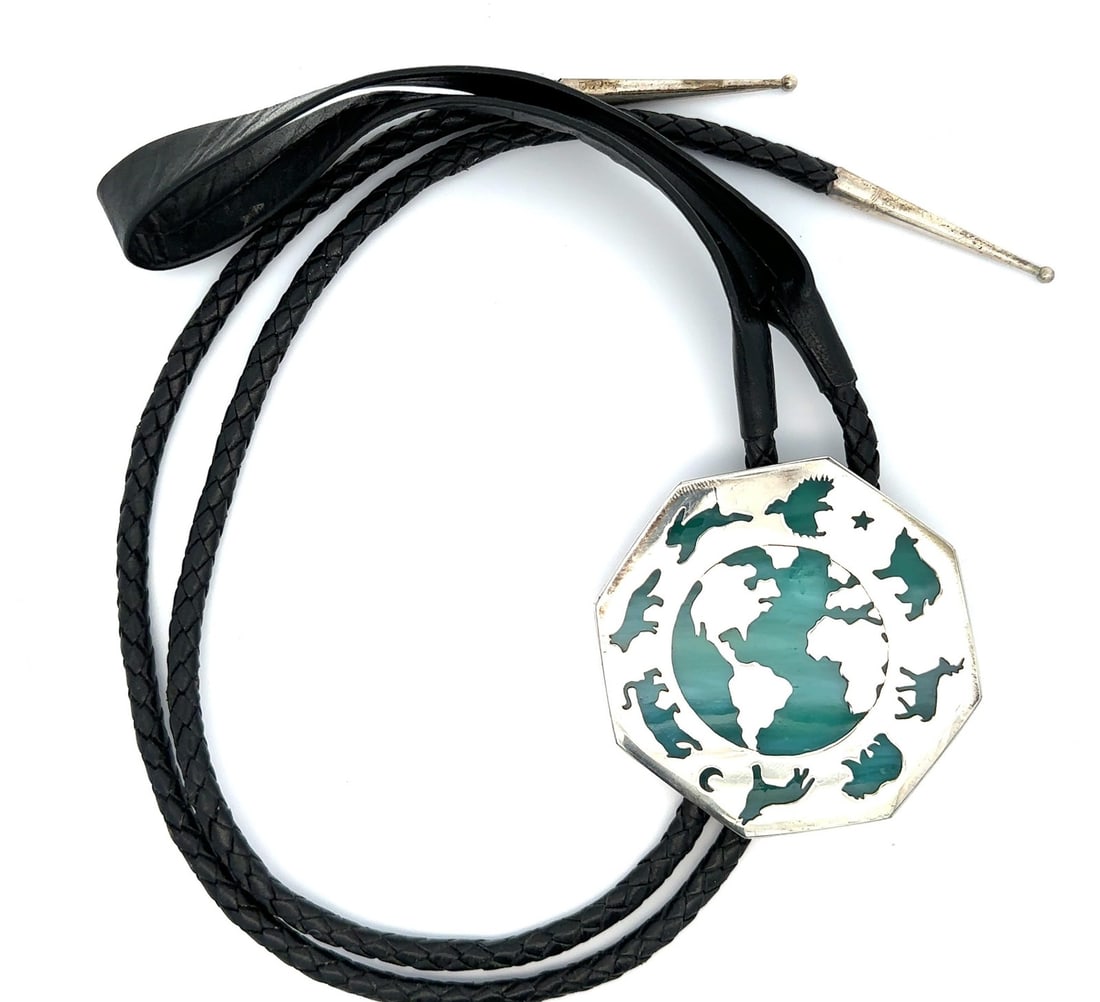 Sterling Silver Stained Glass Bolo Tie with World Map Animal Motif: Sterling Silver Stained Glass Bolo Tie with World Map Animal Motif This bolo tie features a stained glass world map design with animal details, set in sterling silver. The centerpiece is paired with a