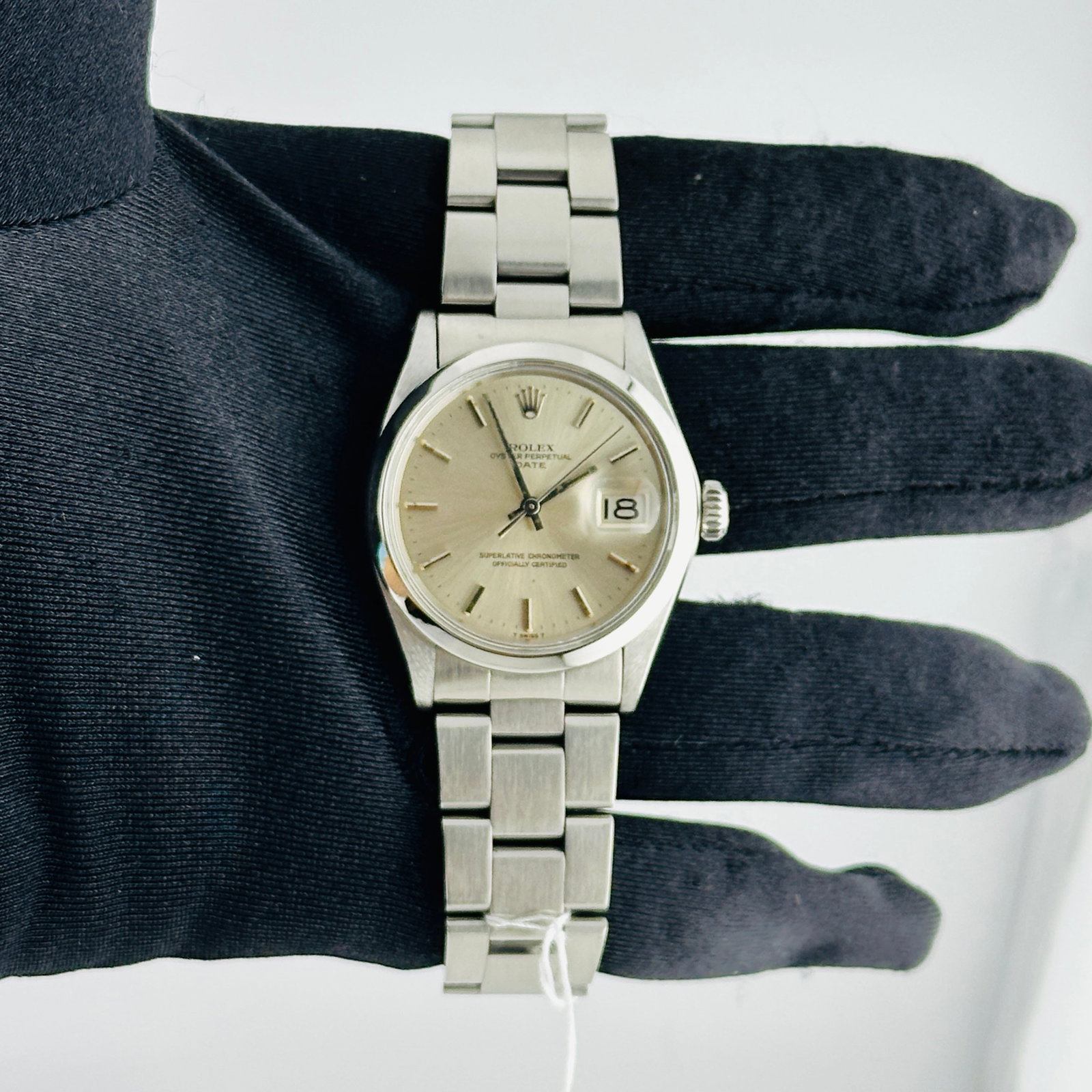 Rolex Oyster Perpetual Date Ref 1500 Silver Dial Watch with Oyster Bracelet: Rolex Oyster Perpetual Date Ref 1500 Silver Dial Watch with Oyster Bracelet This Rolex Oyster Perpetual Date features a silver stick dial, a smooth bezel, and is paired with an Oyster bracelet. Design