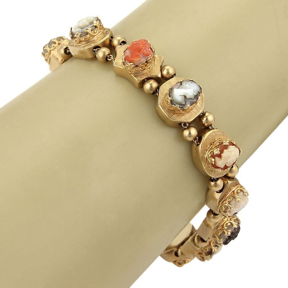 Vintage 14k Yellow Gold Cameo Slide Bracelet: Vintage 14k Yellow Gold Cameo Slide Bracelet This vintage slide bracelet is crafted from solid 14k yellow gold and features an elegant assortment of decorative gemstone slides, including classic cameo
