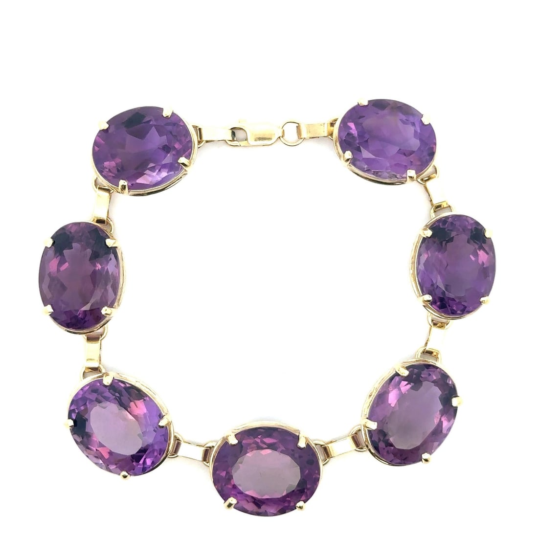 Vintage 50ctw Oval Amethyst Yellow Gold Link Bracelet 14k: Vintage 50ctw Oval Amethyst Yellow Gold Link Bracelet 14k This stunning vintage bracelet features a substantial design crafted from solid yellow gold. Set with seven natural oval amethysts, each brill