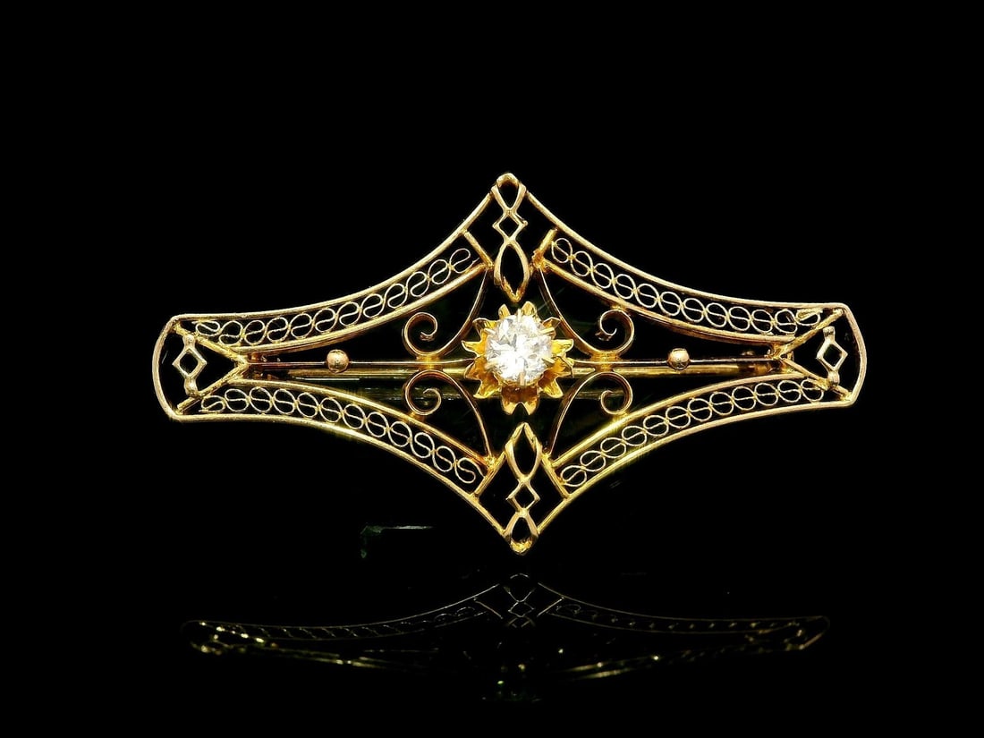 Antique Art Deco 10k Gold .14ct Diamond Filigree Brooch: Antique Art Deco 10k Gold .14ct Diamond Filigree Brooch This exquisite Antique Art Deco brooch features a stunning solitaire diamond, elegantly set in a delicate open filigree design. Crafted from sol
