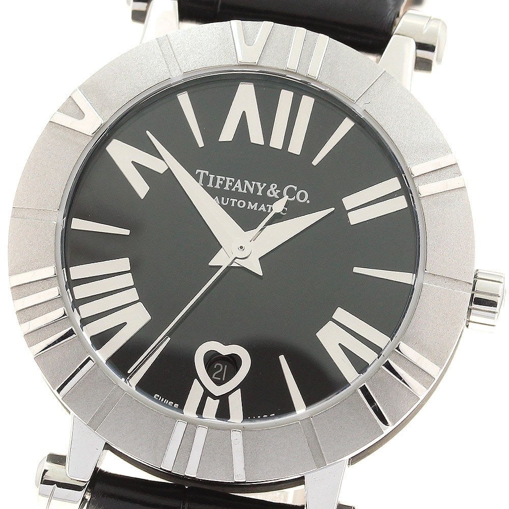 Tiffany Atlas black dial automatic women's date watch: Tiffany Atlas black dial automatic women's date watch This Tiffany & Co. Atlas Date women's wristwatch features a stainless steel and ceramic case with a black dial and a leather band. The watch is po