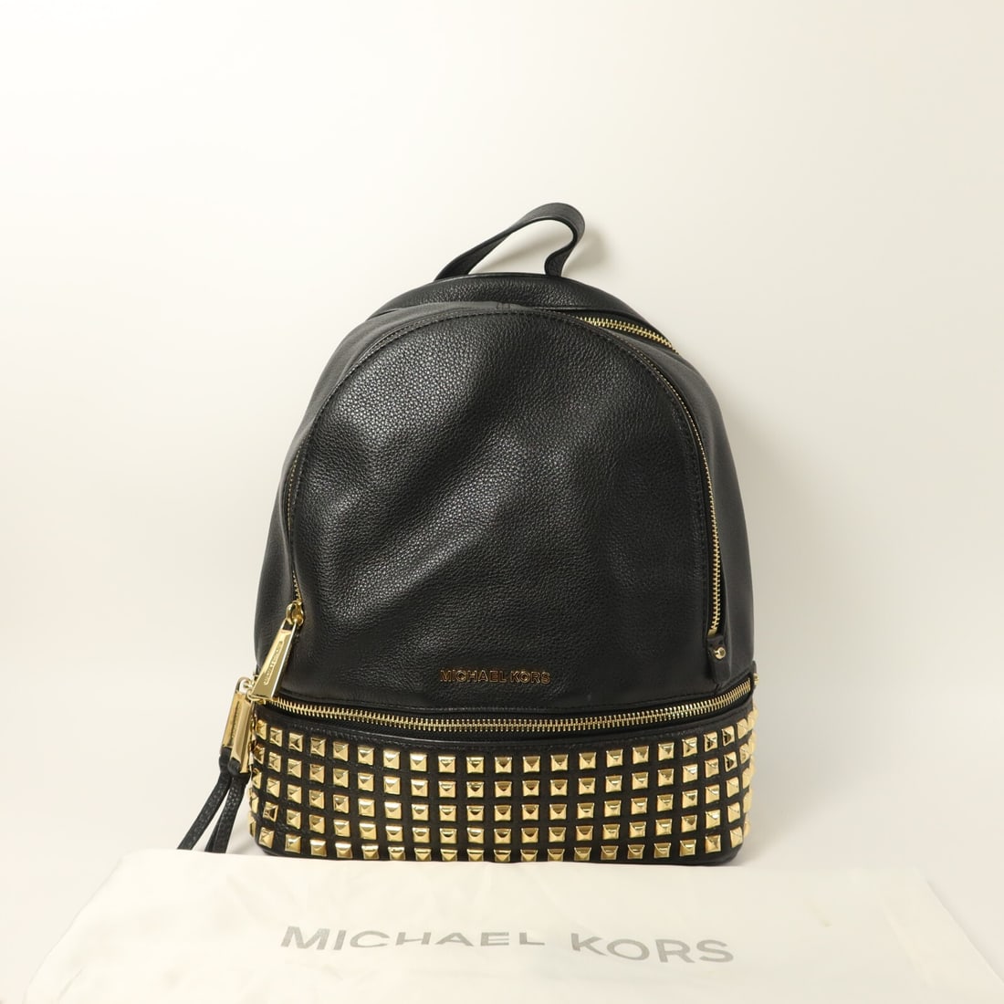 Michael Kors Rhea studded calfskin backpack black GHW: Michael Kors Rhea studded calfskin backpack black GHW This Michael Kors Rhea studded rucksack backpack is crafted from black calfskin leather, offering both style and durability. Featuring gold-tone h