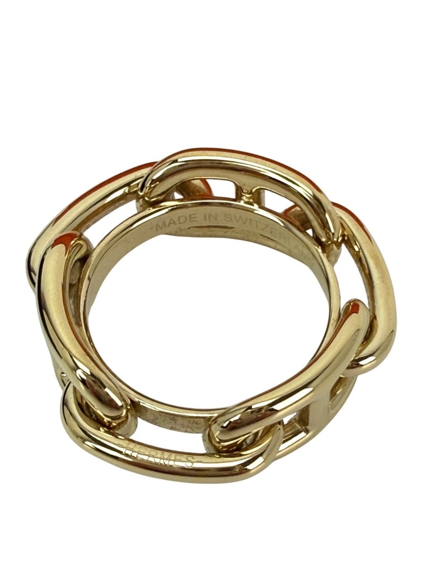 Hermes Gold Metal Scarf Ring: Hermes Gold Metal Scarf Ring This Hermes Regate scarf ring is crafted from gold-tone metal and features the iconic Hermes logo accent. Designed in a round shape, it is intended to securely hold scarve