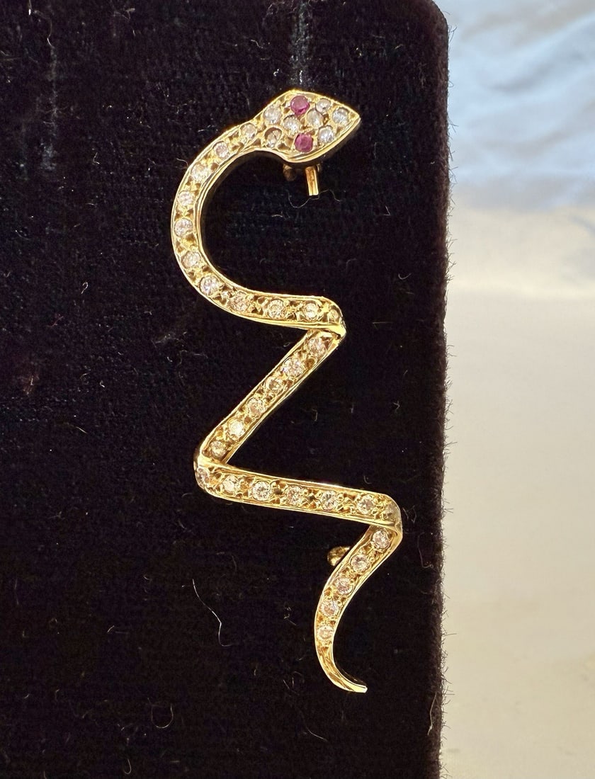 Exquisite 18K Yellow Gold Diamond Ruby Snake Brooch: Exquisite 18K Yellow Gold Diamond Ruby Snake Brooch This exquisite brooch features a stunning snake design crafted from 18K yellow gold, adorned with sparkling diamonds and vibrant rubies. Its intrica