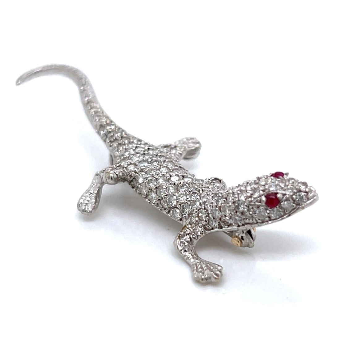 Diamond and Ruby Lizard Brooch in 18K White Gold 2.5 Inch: Diamond and Ruby Lizard Brooch in 18K White Gold 2.5 Inch This brooch is crafted in 18K white gold and designed in the shape of a lizard. It features approximately 100 diamonds with a total weight of 