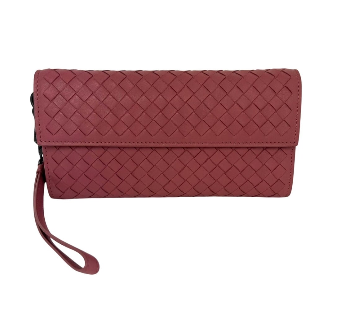 Pink Leather Wristlet Wallet by Bottega Veneta Intrecciato: Pink Leather Wristlet Wallet by Bottega Veneta Intrecciato This Bottega Veneta Intrecciato wallet wristlet features a solid pink leather design with a flap closure and an attached strap. The small-siz