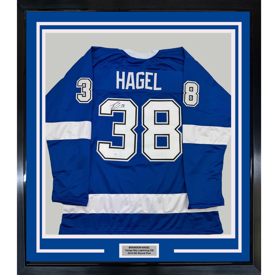 Framed Autographed Brandon Hagel Jersey Tampa Bay Lightning JSA COA 35x39: Framed Autographed Brandon Hagel Jersey Tampa Bay Lightning JSA COA 35x39 This professionally framed and matted display features an autographed blue jersey of NHL player Brandon Hagel, representing th