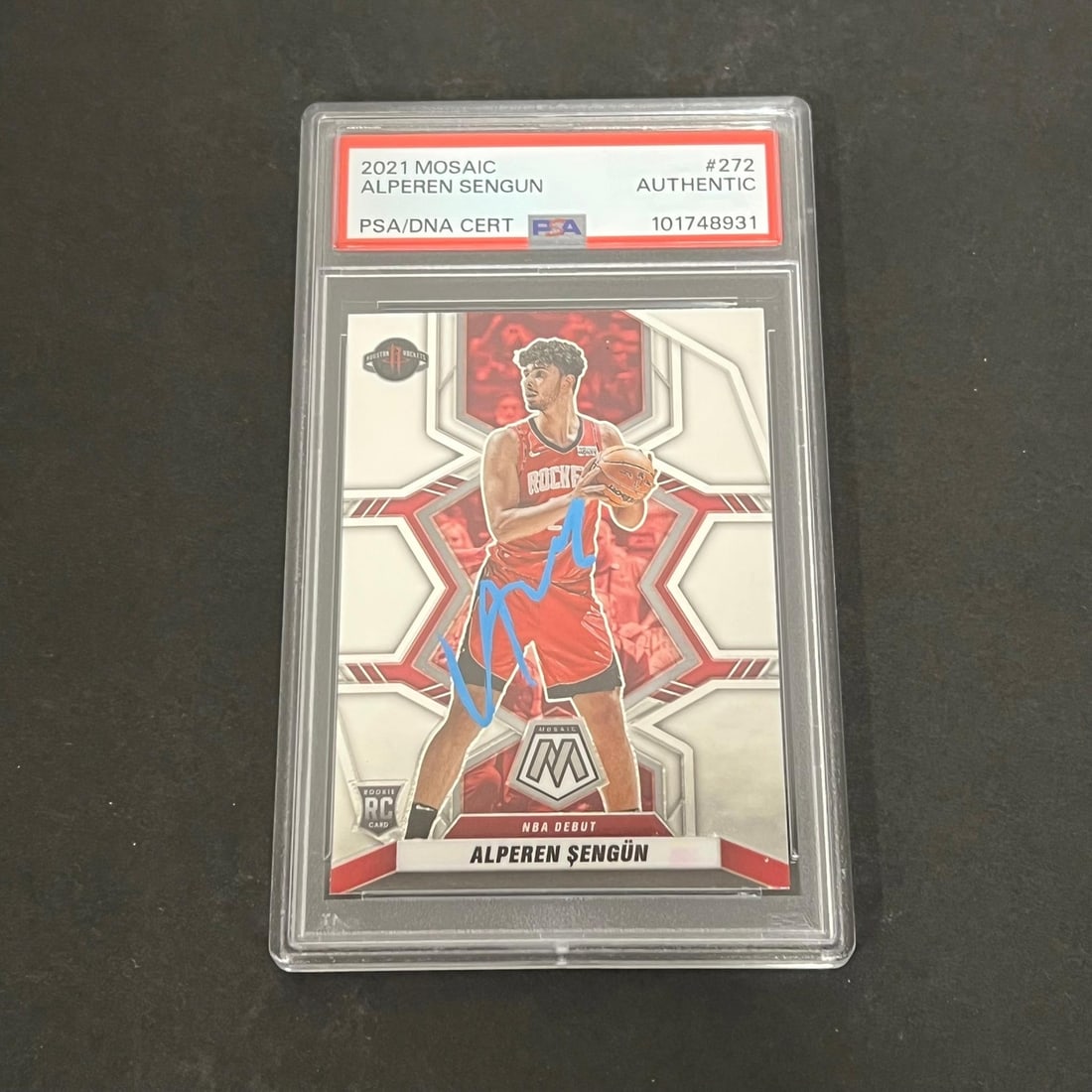 2021-22 Panini Mosaic #272 Alperen Sengun Signed PSA Card: 2021-22 Panini Mosaic #272 Alperen Sengun Signed PSA Card This is a 2021-22 Panini Mosaic #272 sports trading card autographed by Alperen Sengun of the Houston Rockets. The card is a standard size and